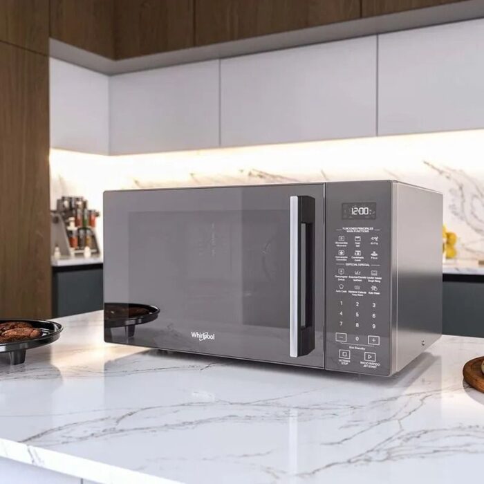 Horno microondas Whirlpool plateado sobre encimera de cocina moderna con acabado en mármol