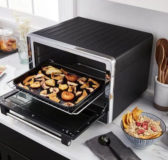 Horno de mesa moderno deshidratando frutas en cocina luminosa y contemporánea.