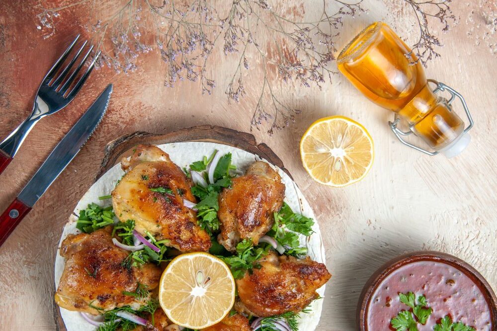 Pollo al limón, hierbas frescas y salsa casera en presentación gourmet preparado en horno de mesa.