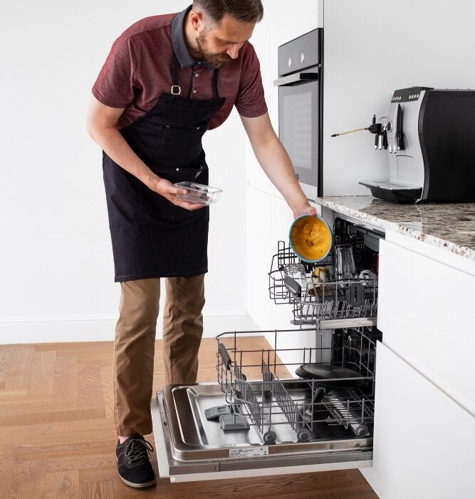 Hombre organizando vajilla para ser lavada en Lavadora de platos